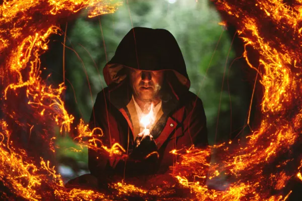 Mann mit Licht in der Hand, umgeben von einem Feuerring, erstellt aus Feuer-Texturen.